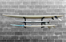 Load image into Gallery viewer, Wall mounted on brick wall surfboard racks powder coated black to hold 3 surfboards or mal